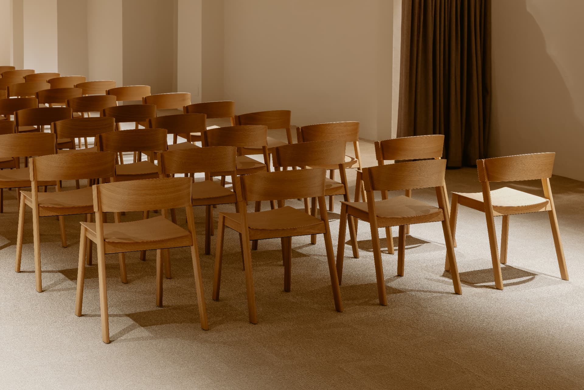 Rows of light wood chairs in a bright professional space